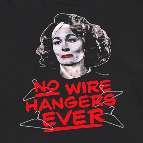 A black short-sleeve graphic t-shirt featuring a stylized portrait of a woman with the text 'NO WIRE HANGERS EVER' in red and white, displayed flat against a light cream background.