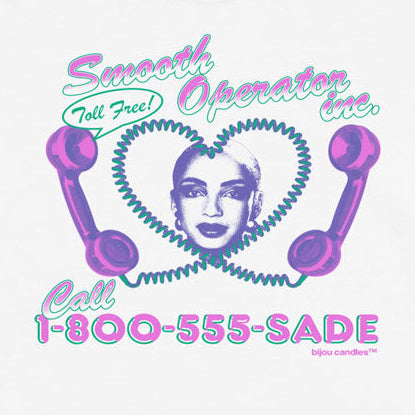 A white short-sleeve t-shirt with a retro graphic on the front featuring purple rotary phones, a heart-shaped face, and the text 'Smooth Operator Inc. Call 1-800-555-SADE'.