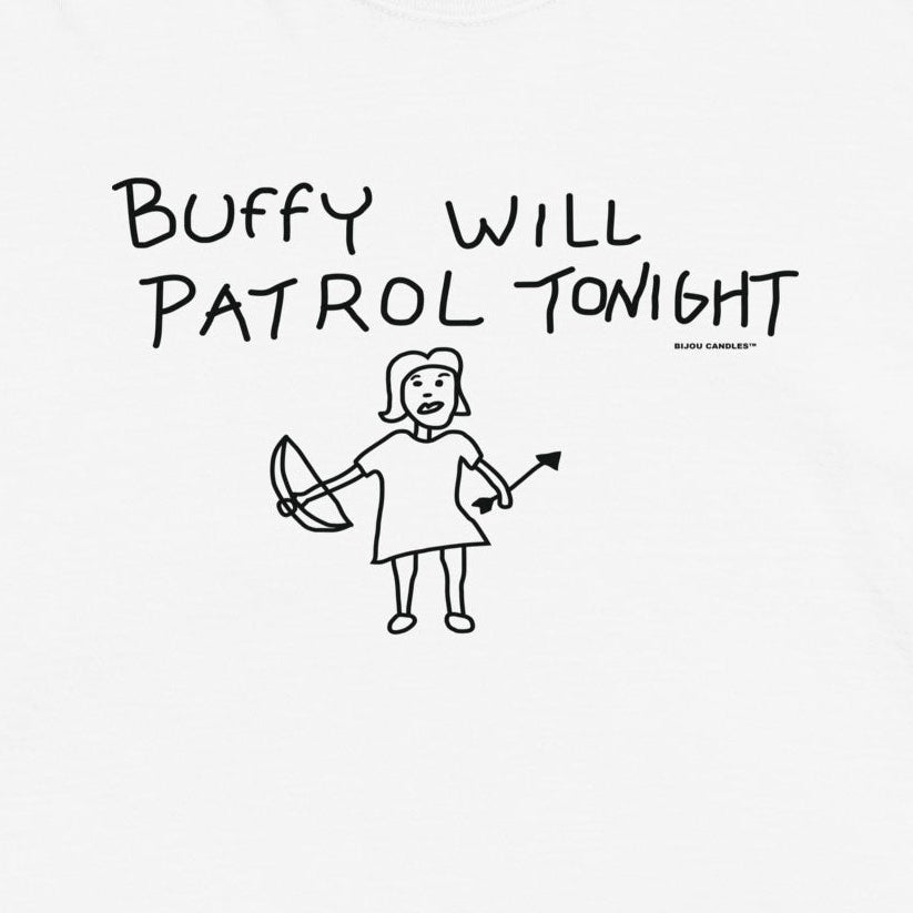 A white short-sleeve t-shirt with a black hand-drawn style graphic on the chest that reads 'BUFFY WILL PATROL TONIGHT' above a simple figure holding a weapon. The t-shirt is displayed flat against a light cream background.