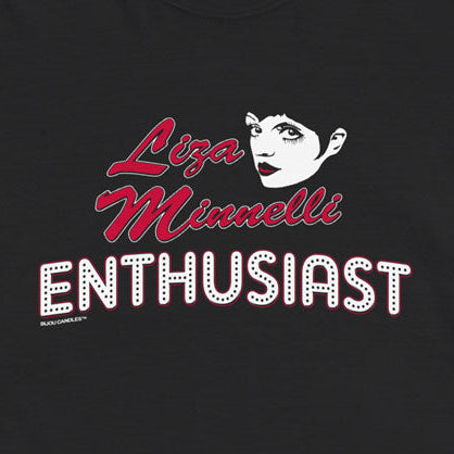 A black short-sleeve graphic t-shirt featuring a stylized print of a woman's face and the text 'Liza Misnellis ENTHUSIAST' in red and white, displayed flat against a light cream background.