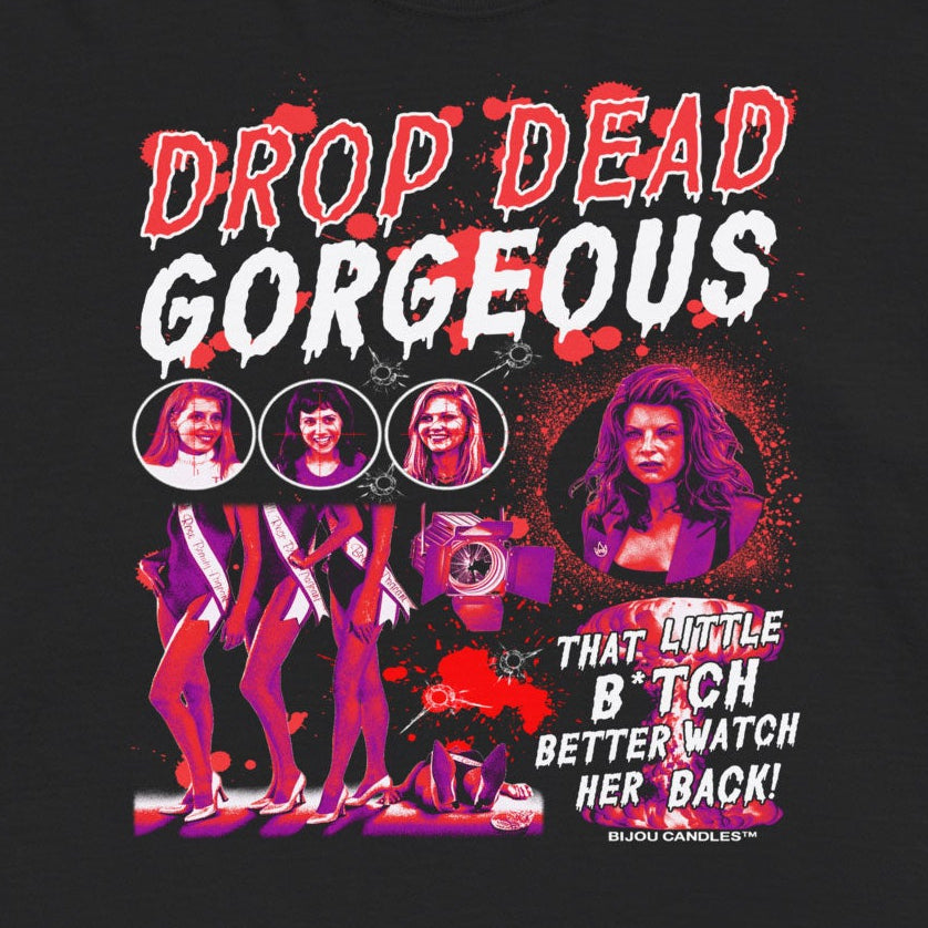 A black short-sleeve graphic t-shirt featuring a vibrant pink, red, and white print on the front with the text 'DROP DEAD GORGEOUS' and a stylized illustration of a woman.